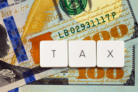 Tax concept - letter tag on money backgroundの写真素材