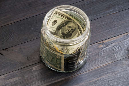 Saving concept - currency in glass jarの写真素材