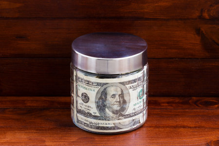 Glass jar with dollar bills. Money saving concept.