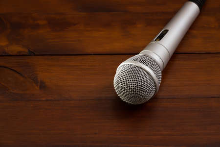 Gray microphone on a stylish dark wooden backgroundの写真素材