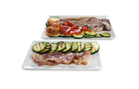 Pair of square plates with meat stick and vegetables isolated on whiteの写真素材