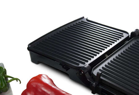 Black electric grill cooking meat with vegetables isolated on whiteの写真素材