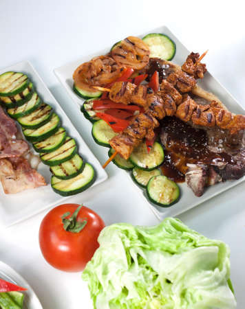 Pair of square plates with meat stick and vegetablesの写真素材