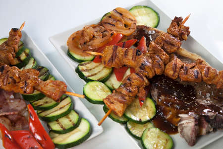 Pair of square plates with meat stick and vegetablesの写真素材