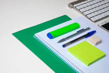 view of an office desk with pen, block note, keyboard and folderの写真素材