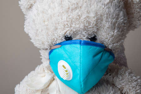 Teddy bear protected by KN95 face mask protection against pm 2.5 contamination and COVID-19 coronavirus. child conceptの写真素材