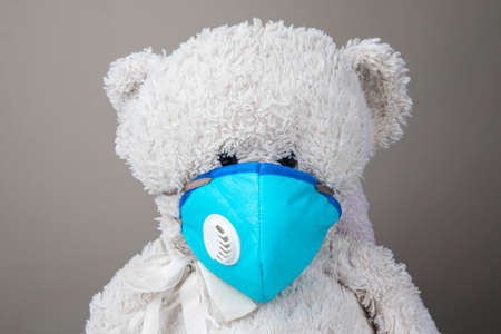 Teddy bear protected by KN95 face mask protection against pm 2.5 contamination and COVID-19 coronavirus. child conceptの写真素材