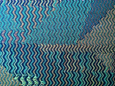 Background or texture with wavy distortion effect of a green, beige and blue woven cloth rug, forming a beautiful pattern.の写真素材