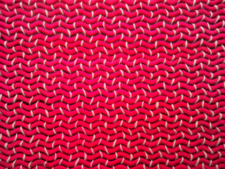 Background or texture of a distorted handicraft with pink twigs and braided strings, forming an...