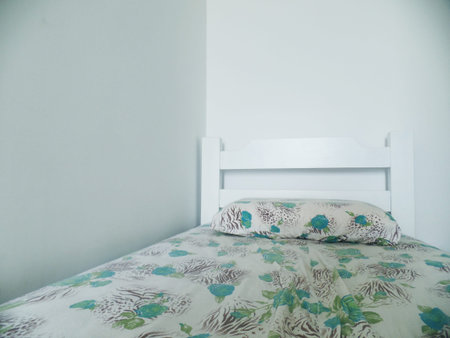 Single white bed with flower stampsの写真素材