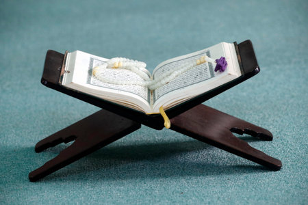 Mubarak mosque. An open Holy Quran and a muslim prayer beads on wood stand Chau Doc. Vietnam.