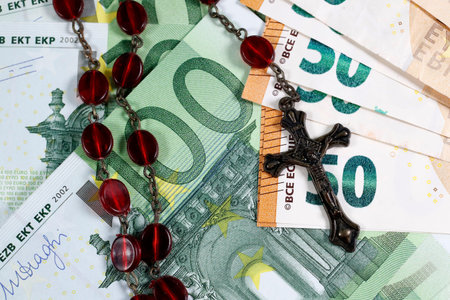 Catholic finance and economy concept with rosary. Banknotes of euro currency.