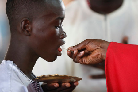 African church. Sunday catholic mass. Priest given holy communion. Agbonou Koeroma. Togo.
