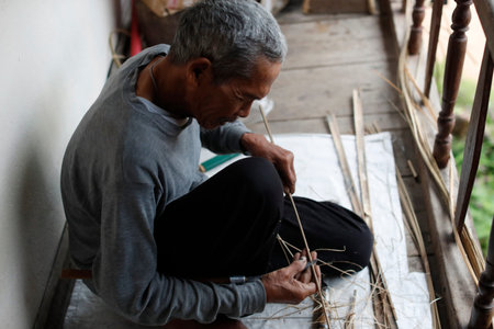 Bahnar (Ba Na) ethnic group. Old man using draw on wood. Kon Tum. Vietnam.