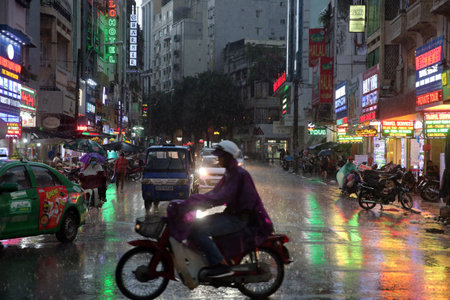 Heavy monsoon rain. Motor Scooters on Saigon Street. Vietnam.