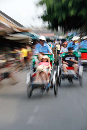 Tourist riding in cyclo (three wheeled bicycle taxis). Hoi An. Vietnam.の写真素材
