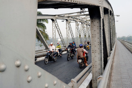 Scooters crossing the famous Trang Tien bridge in morning rush hour traffic. Hue. Vietnam.の写真素材