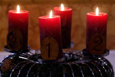 Natural advent wreath or crown in a catholic church with Four burning red candles. France.の写真素材