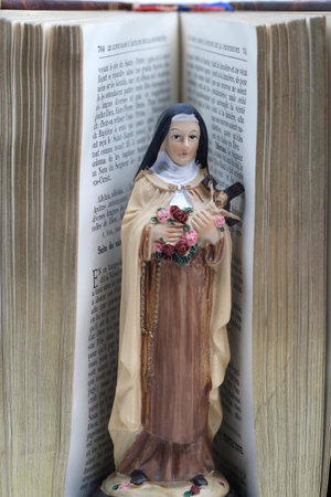 Bible and Saint Therese de Lisieux figurine. Also known as Saint ThÃ©rÃ¨se of the Child Jesus and the Holy Face. France.の写真素材