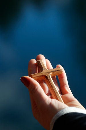 Christian wooden cross in hand. Faith and spirituality.の写真素材