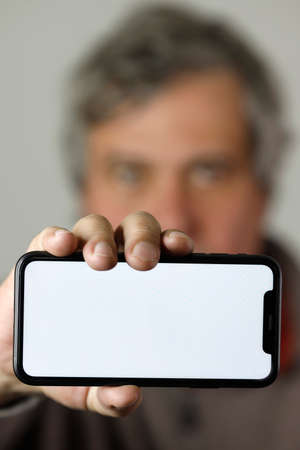 Man showing a smartphone with a blank screen. France.の写真素材