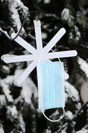 Surgical mask on Christmas tree. Coronavirus (Covid-19) epidemic.