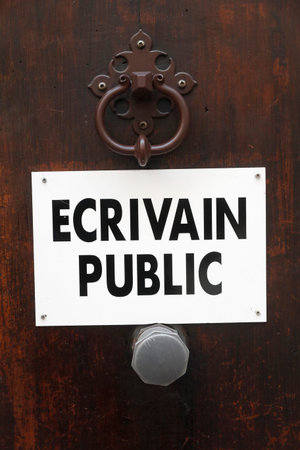Public letter writer sign on a door. Cannes. France.