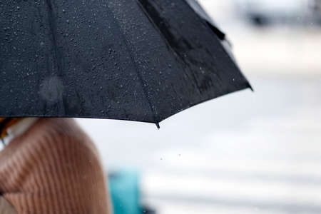 People walking with umbrella in rainy day scene.  Nazare. Portugal.の写真素材