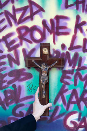 Cross against a wall with graffiti. France.の写真素材