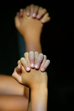Young prayers in a church. Closeup on hands.