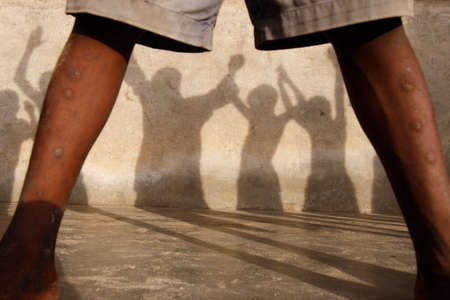 Figures. African schoolchildren holding hands. Shadow. Togo.のeditorial素材