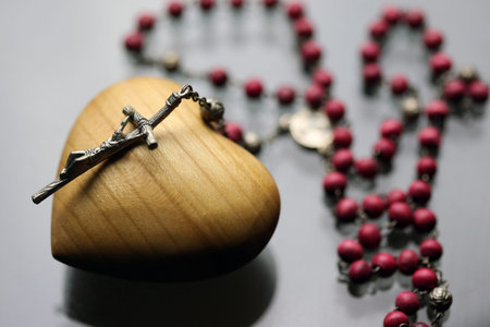 Rosary on a carved wooden heart. France.の写真素材
