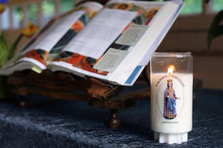 Sanctuary of La Benite Fontaine. Church candle and open bible. La Roche-sur-Foron. France.のeditorial素材