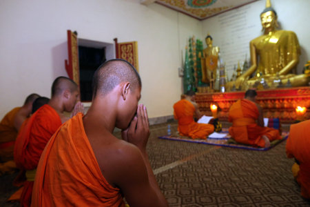 The Buddhasima or Sim: the Buddhist temple's most sacred complex. Group of seated, young Buddhist...