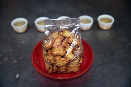 Buddhist chinese temple. Offerings. Cookies and tea. Bangkok.Thailand.のeditorial素材