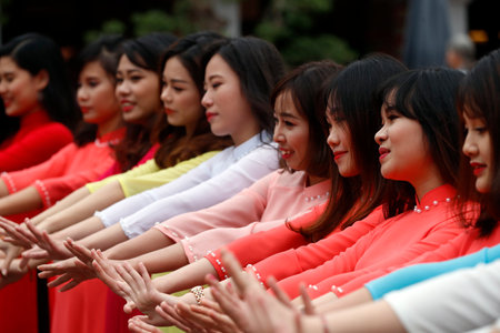 Vietnamese graduates wearing tradional dress, Ao Dai at Temple of Literature Hanoi. Vietnam.のeditorial素材