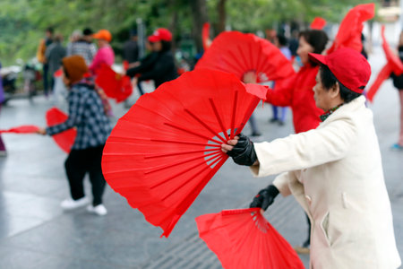 Early morning tai chi session along the banks of Hoan Kiem lake. Exercises with fans. Ha Noi. Vietnam.のeditorial素材