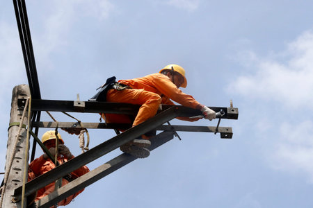 Maintenance electrician repairing electricity pylon. Cai Be. Vietnam.