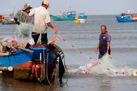 Fishermen repairing fishing nets. Hang Dua bay. Vung Tau. Vietnam.のeditorial素材