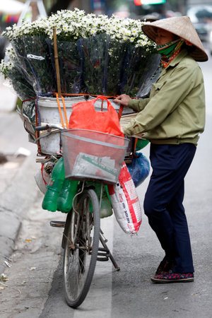 Vendor selling flowers from her mobile bicycle shop. Ha Noi. Vietnam.のeditorial素材
