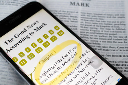 Paper Bible and digital Bible app on smartphone. The New Testament. Gospel. Mark.