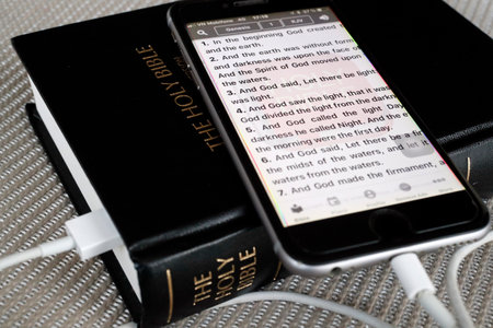 Paper Bible and digital Bible app on smartphone.の写真素材