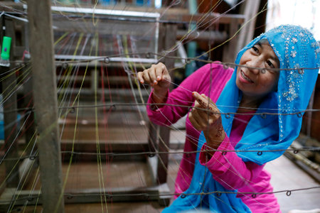 Traditional hand loom. Local muslim woman diligently weaving colorful scarves. Chau Doc. Vietnam.のeditorial素材