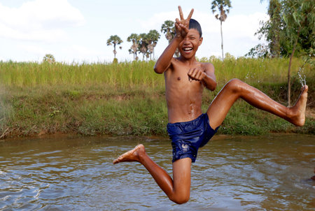 Teenage boy jumping into river. Kep. Cambodia.のeditorial素材
