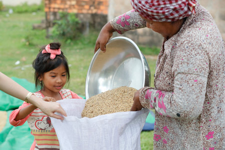 Rice. Family filling bags with harvested grain. Kep. Cambodia.のeditorial素材