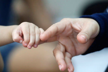 Father and son. Close-up on hands. Ho chi Minh city. Vietnam.のeditorial素材