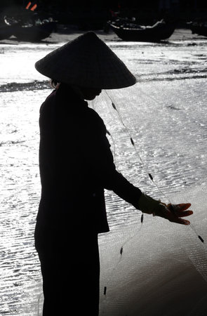South China Sea. Woman repairing fishing nets. Vung Tau. Vietnam.のeditorial素材