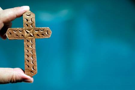 Christian cross against the sky. Close-up on hand. Kep. Cambodia.
