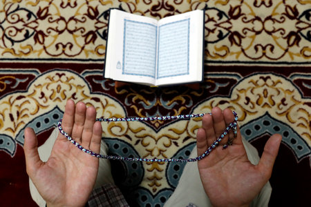 Muslim man praying with prayer beads (Masbahah). Close-up.のeditorial素材