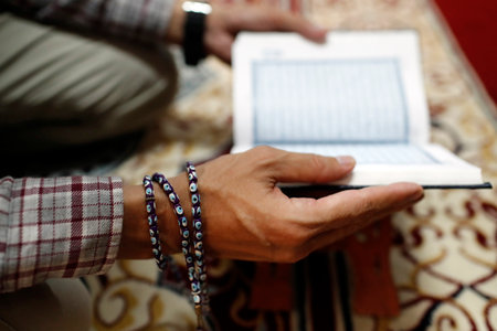 Man reading the Noble Quran. Close-up.のeditorial素材